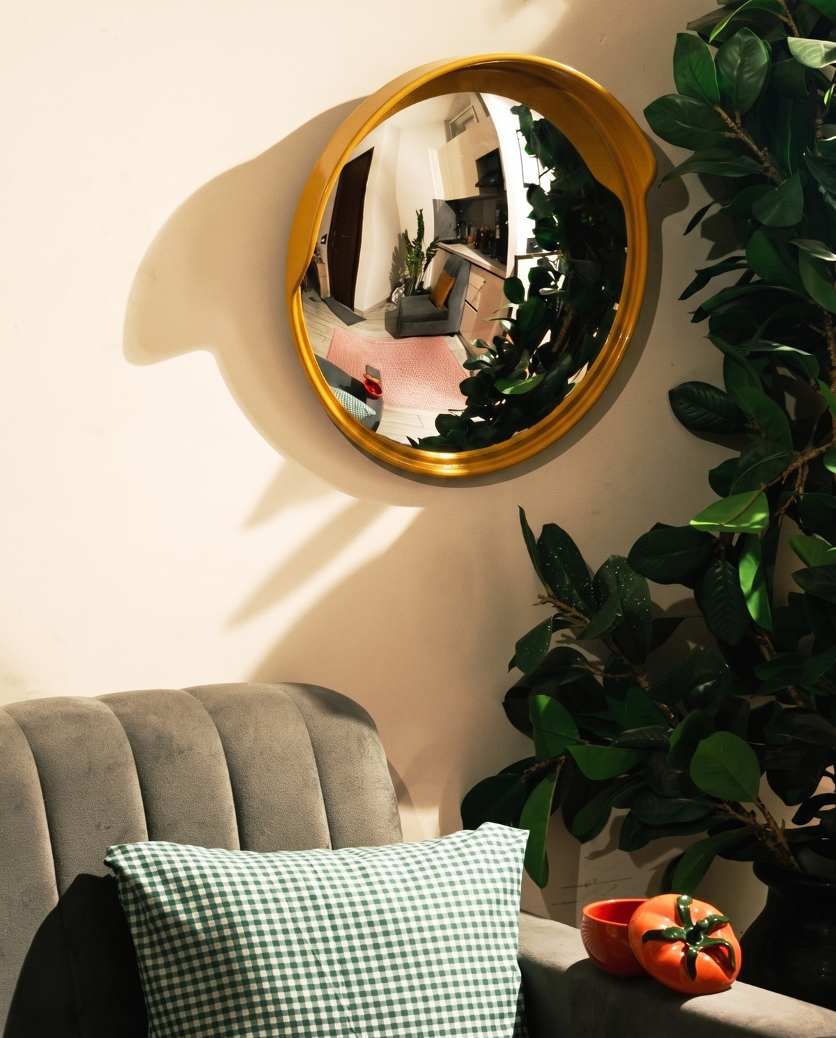MIRROR SPECTACULAR in island yellow, hung on a cream wall above a grey velvet sofa